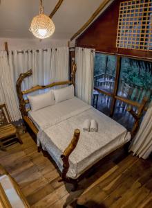 a bedroom with a bed with two shoes on it at LAMIACEAE WOOD CABIN in Ella
