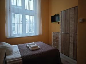 a bedroom with a bed with two towels on it at Willa Księżniczki Sopotu in Sopot