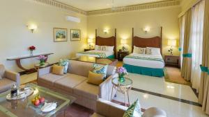 a hotel room with two beds and a living room at Ramgarh Lodge, Jaipur – IHCL SeleQtions in Jaipur