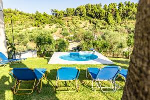 a group of chairs and a pool in the yard at Skioni Studios in Nea Skioni