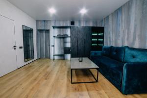sala de estar con sofá azul y mesa en Rado Hotel Spa en Khmil'nyk
