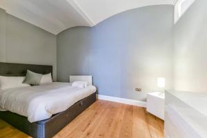 a bedroom with a bed and a wooden floor at 2 Bed Flat South Kensington in London