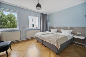 a bedroom with a large bed and two windows at limehome Dresden Tannenstraße in Dresden