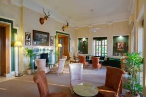 a living room with chairs and a fireplace at Ramgarh Lodge, Jaipur – IHCL SeleQtions in Jaipur