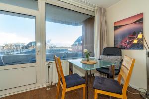 una sala da pranzo con tavolo, sedie e una finestra di Sylter Krabbe a Westerland