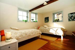 two beds in a room with two windows at Holiday home Rosenhof, Lenzen in Lenzen