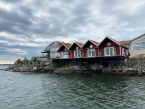 a red house on a pier next to the water at ÖMC Kurshotell in Öckerö