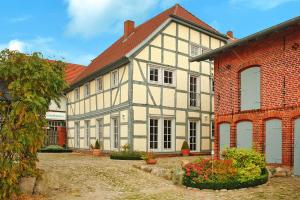 Casa grande blanca y gris con un edificio de ladrillo en Holiday home Rosenhof, Lenzen en Lenzen