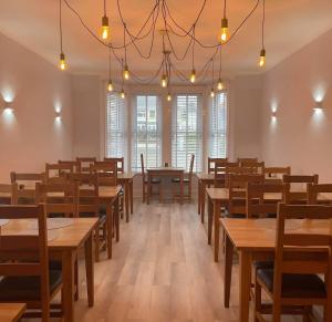een eetkamer met tafels, stoelen en ramen bij Pine Lodge in Newquay