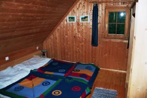 ein Schlafzimmer mit einem Bett in einer Holzhütte in der Unterkunft Bischofhütten in Bad Sankt Leonhard im Lavanttal