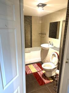a bathroom with a toilet and a tub and a sink at LONDON FRESHAir BREATHE APARTMENT in London