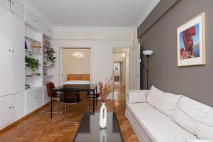 uma sala de estar com um sofá branco e uma mesa em Athenian Apartment in Kolonaki em Atenas