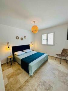 ein Schlafzimmer mit einem großen Bett und einem Stuhl in der Unterkunft "Villa Querciu" Villa neuve & piscine privée in Prunelli-di-Fiumorbo
