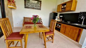 una cocina con una mesa de madera con un jarrón de flores. en Villa magica, en Ubud