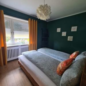 a bedroom with a bed and a green wall at Eure Auszeit überm See in Markdorf