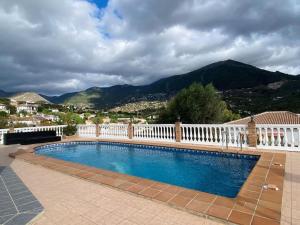 a swimming pool with a white fence and mountains at Exclusive House with Incredible Mountain Views in Alcaucín