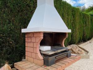 um forno de tijolos ao ar livre com um telhado branco em Exclusive House with Incredible Mountain Views em Alcaucín