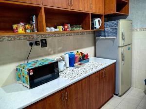 um balcão de cozinha com um micro-ondas e um frigorífico em Top View Synergy Square em Kuching