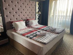 a bed with a headboard and pillows on it at Мия 2 Deluxe Royal Spa in Velingrad