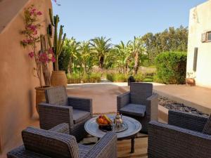 a patio with chairs and a table with a bowl of fruit at Dar Maha - Amazing villa - pool 15x5M can be heated in Essaouira