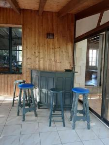 tres taburetes azules en un patio con una barra en Maison en Vendée avec Piscine, en Corpe
