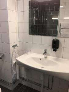 a bathroom with a white sink and a mirror at ÖMC Kurshotell in Öckerö