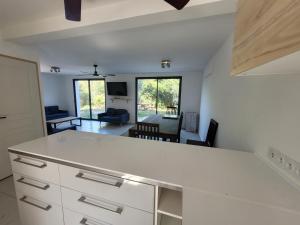 a kitchen with a white counter and a living room at Villas au brusc près de la plage in Six-Fours-les-Plages
