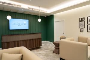 uma sala de espera numa hora de biblioteca com uma televisão de ecrã plano em Legacy Hotel Bangkok Sukhumvit em Bangkok