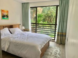 a bedroom with a bed and a large window at Riverside 3 B/Rm Nairobi in Nairobi