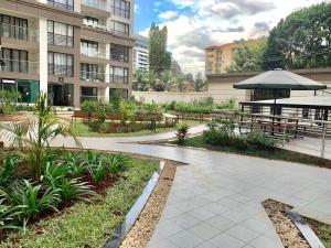 a patio with a table and an umbrella in a building at Riverside 3 B/Rm Nairobi in Nairobi
