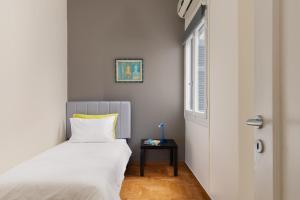 a bedroom with a bed and a side table at Athenian Apartment in Kolonaki in Athens +9 photos