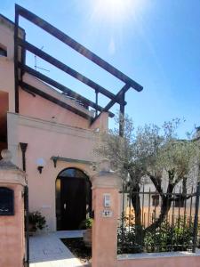 ein Gebäude mit einem Torbogen und einem Gebäude mit einem Zaun in der Unterkunft La Chiocciola Apartments in Santarcangelo di Romagna