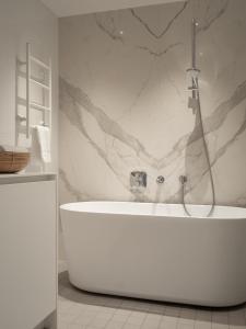 une salle de bain avec baignoire et douche dans l'établissement Bob W Koti Ullanlinna, à Helsinki