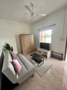a living room with a couch and a flat screen tv at Casa Cactus in Bangrak Beach