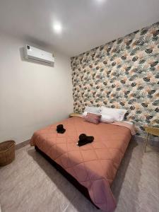 Casa Cactus في Nathon Bay: غرفة نوم بسرير كبير وعليها حذائين سوداوين