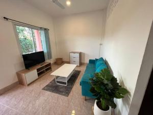 a living room with a blue couch and a tv at Casa Cactus in Bangrak Beach +17 photos