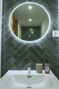 een badkamer met een wastafel en een spiegel bij Mountain View Apartment with Parking & Fast WiFi in Crans-Montana