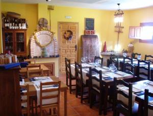 a dining room with tables and chairs and a fireplace at Tres Navíos en el Mar Casa Rural de 10 habitaciones con baño individual precios web in Montejo de Tiermes