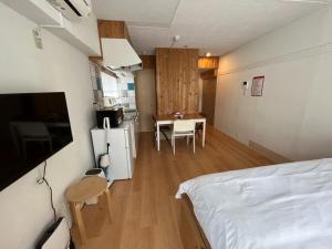 a bedroom with a bed and a table and a kitchen at Rhodes Kagurazaka - Vacation STAY 77350v in Tokyo