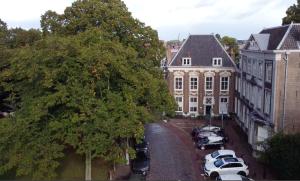 um grupo de carros estacionados num parque de estacionamento ao lado de um edifício em B&B Cleyn Cruysenborgh 1531 em Dordrecht