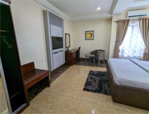 a hotel room with a bed and a television at Newton Park Hotels Annex in Abuja