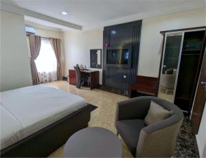 a hotel room with a bed and a chair at Newton Park Hotels Annex in Abuja