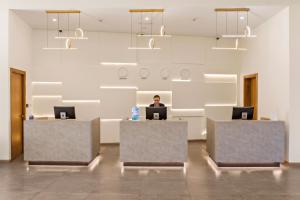 a person sitting at a desk in an office with a laptop at Al Hamra Village Hotel in Ras al Khaimah