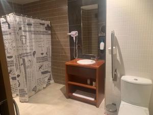 a bathroom with a shower with a sink and a toilet at Buenavista in Cuenca