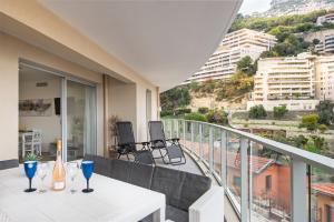 balcón con mesa blanca y vistas a la ciudad en Large terrace, sea view, private parking included en Beausoleil