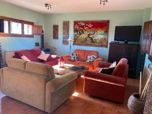 een woonkamer met banken en een flatscreen-tv bij Tres Navíos en el Mar Casa Rural de 10 habitaciones con baño individual precios web in Montejo de Tiermes