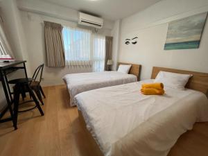 un dormitorio con 2 camas con un animal de peluche amarillo en Rhodes Kagurazaka - Vacation STAY 77334v en Tokio