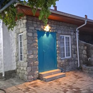 una puerta azul en el lateral de una casa de piedra en İvanovka Butik House, en İvanovka