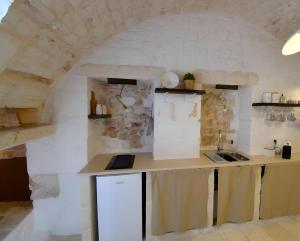 a kitchen with a counter and a stone wall at Casa Matteotti by Wonderful Italy in Conversano