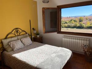 een slaapkamer met een bed en een groot raam bij Tres Navíos en el Mar Casa Rural de 10 habitaciones con baño individual precios web in Montejo de Tiermes